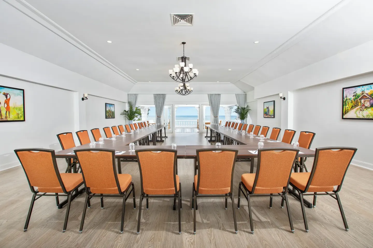 A bright conference room with U-shaped tables and an ocean view at Half Moon.