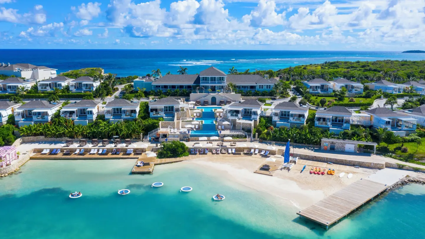 Aerial view of the beach, pools, villas and turquoise water at Hammock Cove Antigua.