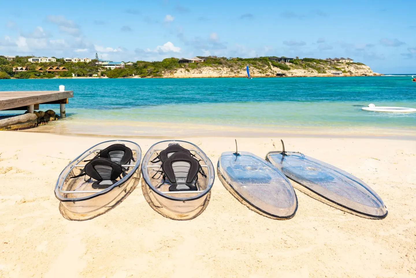 Clear kayaks and paddleboards on the sandy beach at Hammock Cove Antigua.