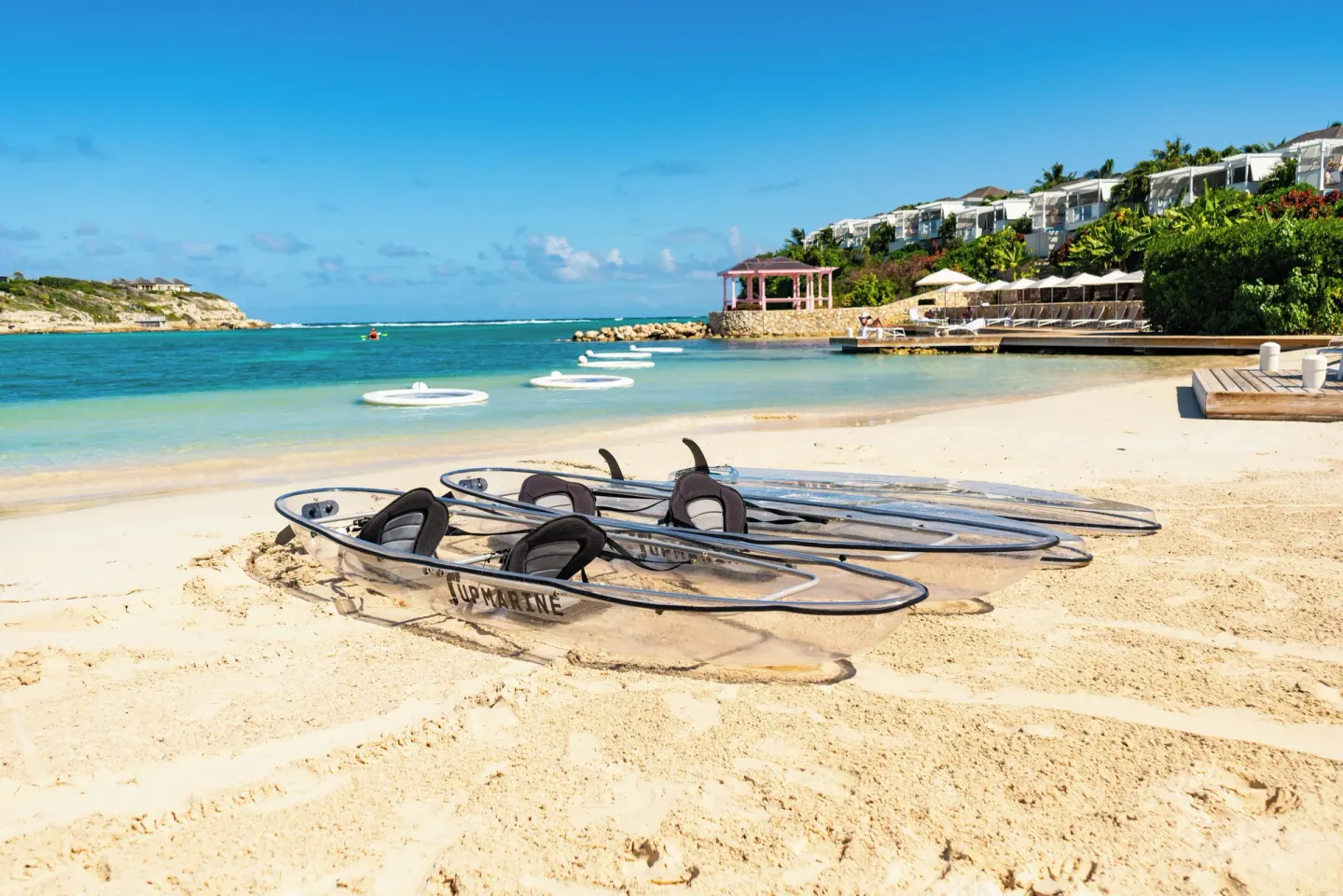 Clear kayaks on the sand facing the cove at Hammock Cove Antigua.