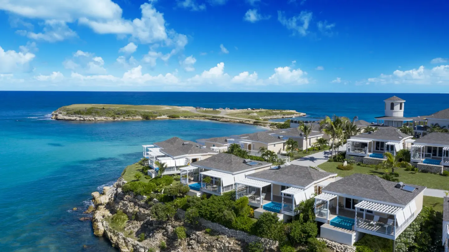 Aerial view of cliffside villas and turquoise water at Hammock Cove Antigua.