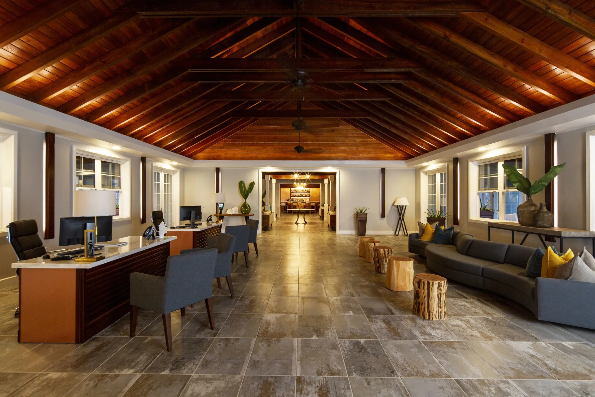Lobby with vaulted wood ceiling, desks, and lounge seating at Hammock Cove Antigua.