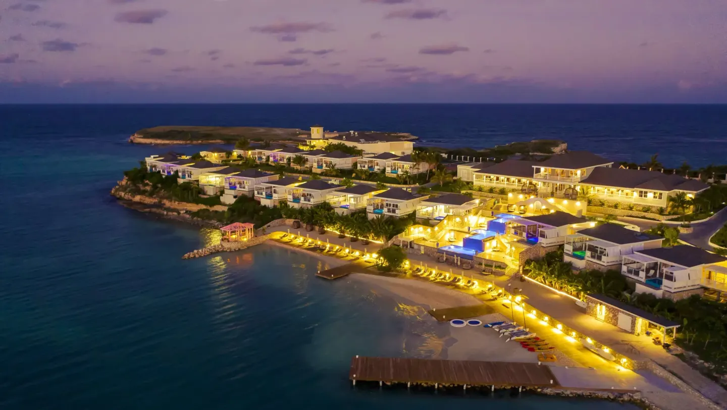 Twilight aerial view of the illuminated resort and beachfront at Hammock Cove Antigua.