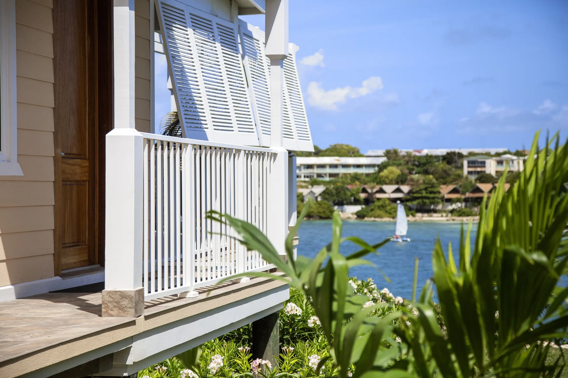 White-railed villa balcony overlooking the water at Hammock Cove Antigua.