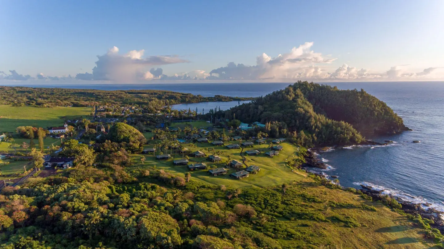 Aerial view of Hana-Maui Resort grounds beside the ocean and wooded headland.