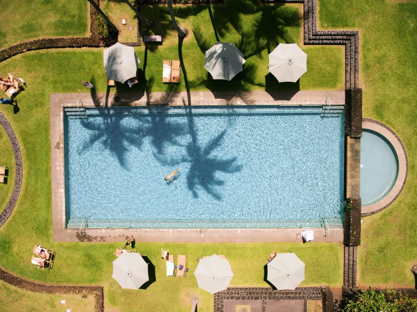 Aerial view of the rectangular pool with umbrellas and loungers at Hana-Maui Resort.