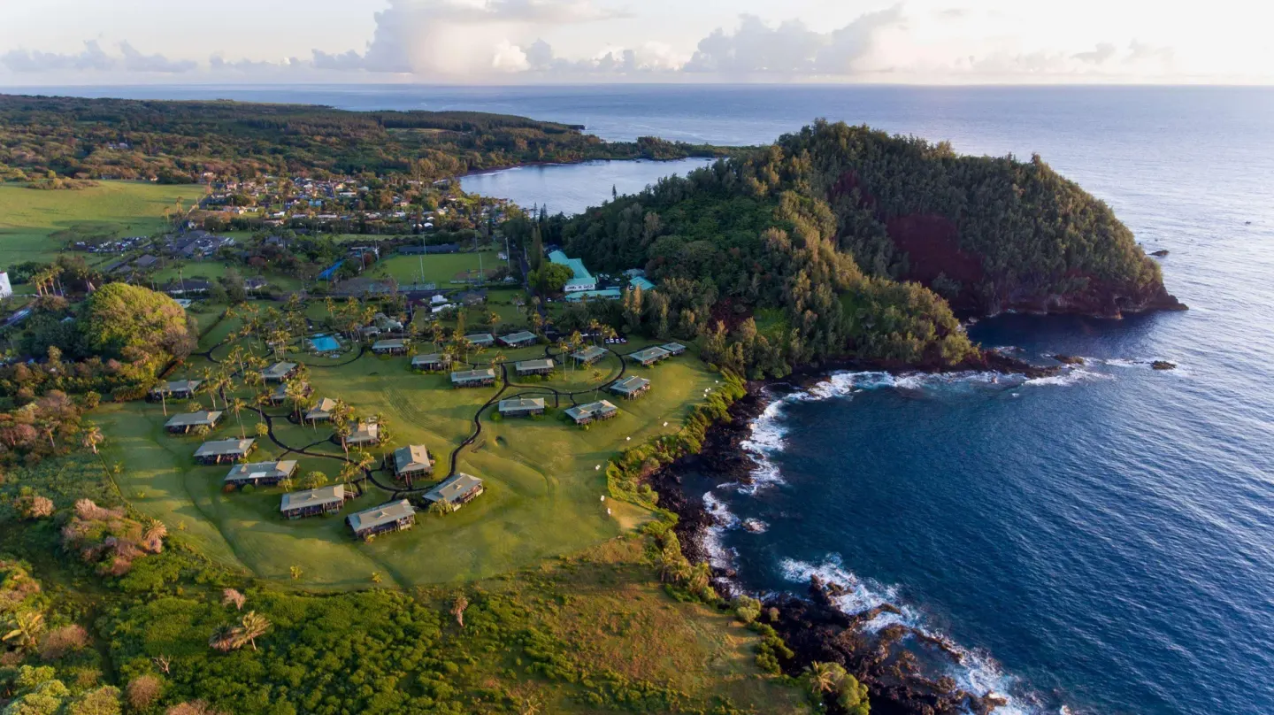 Aerial view of Hana-Maui Resort lawns and cottages along a rocky ocean shoreline.