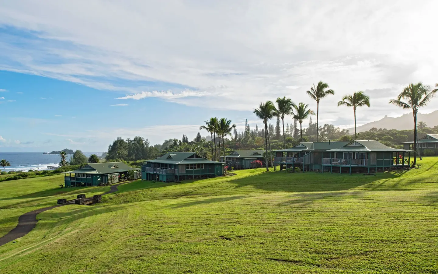 Green lawns, palms, and guest bungalows overlooking the ocean at Hana-Maui Resort.