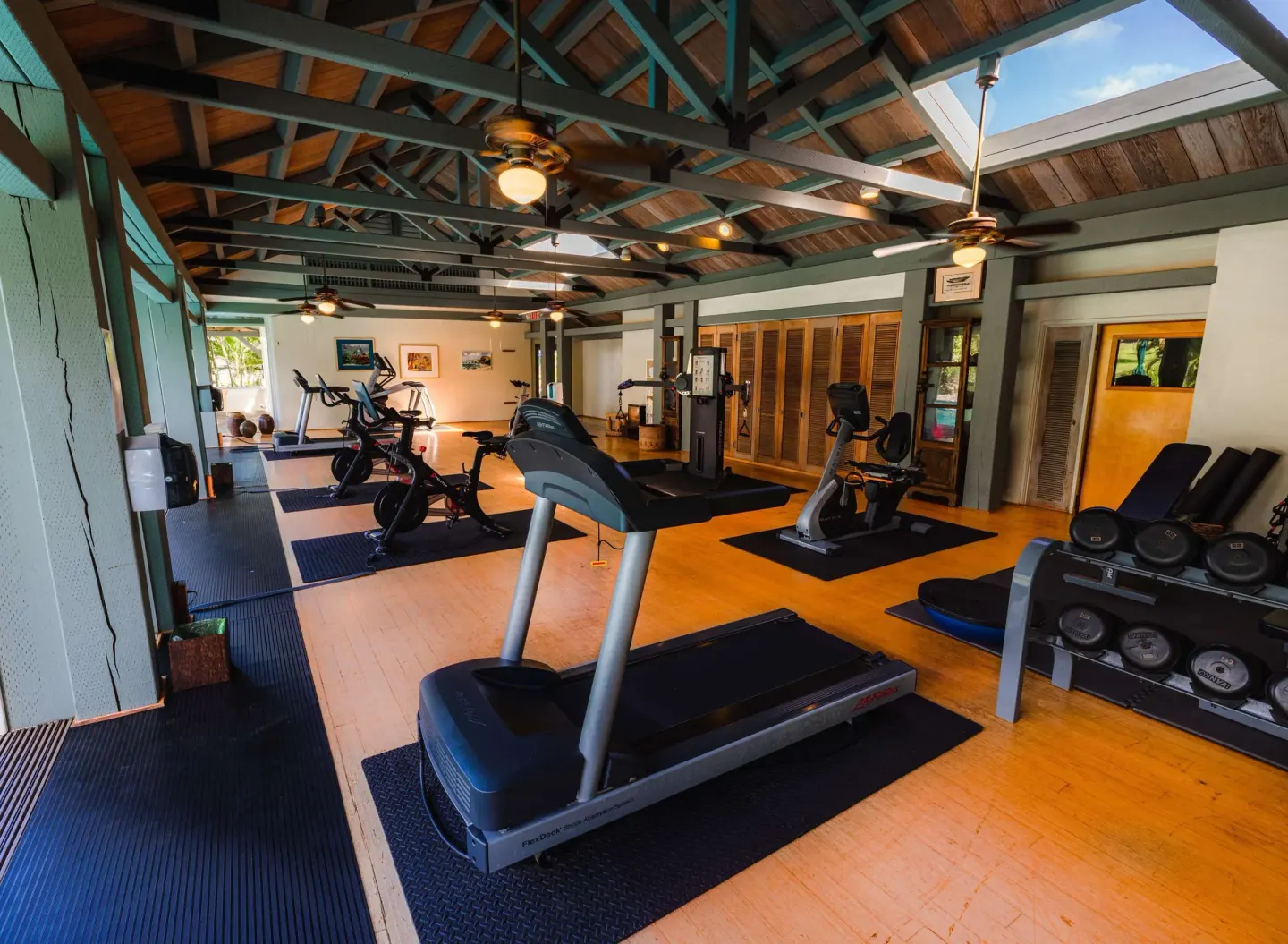 Fitness room with treadmills, bikes, weights, and wood ceiling at Hana-Maui Resort.