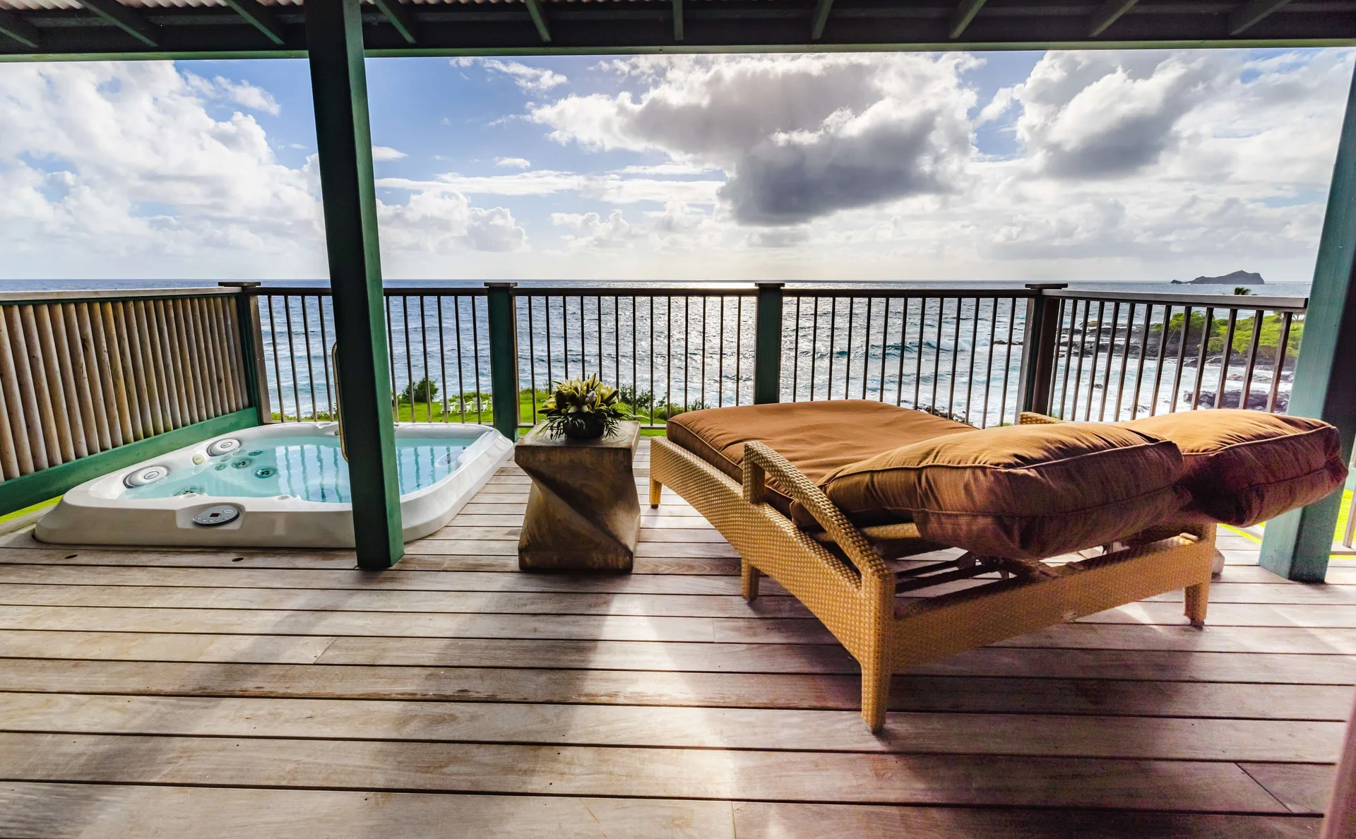 Covered oceanview lanai with hot tub and cushioned loungers at Hana-Maui Resort.