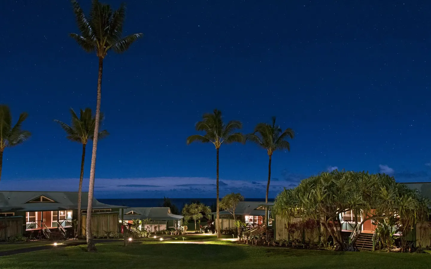 Palm-lined resort paths and bungalows under stars at Hana-Maui Resort.