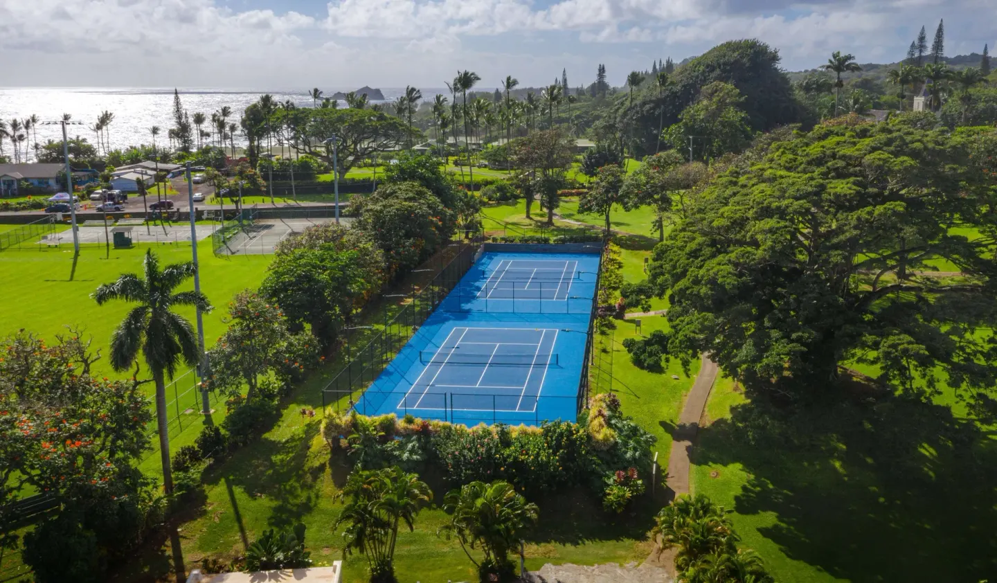 Tennis courts, lawns, palms, and ocean shoreline at Hana-Maui Resort.