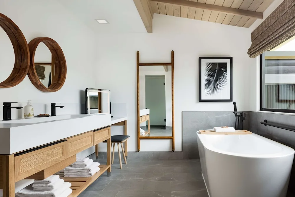 Deluxe Bungalow bathroom with tub, vanity, and mirrors at Hana-Maui Resort.