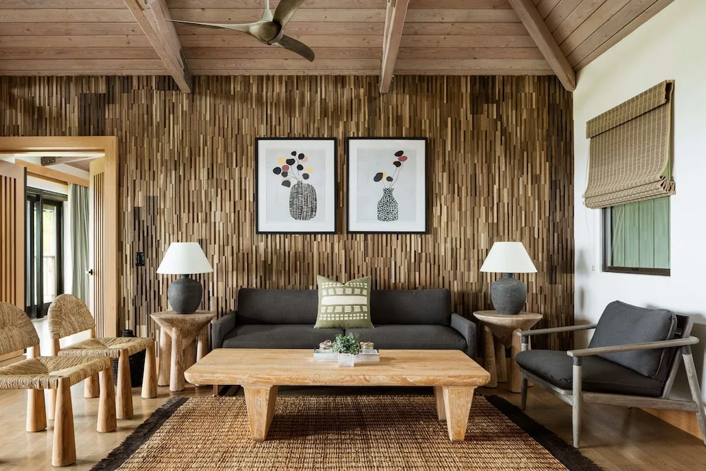 Deluxe Bungalow living area with sofa and woven accent wall at Hana-Maui Resort.