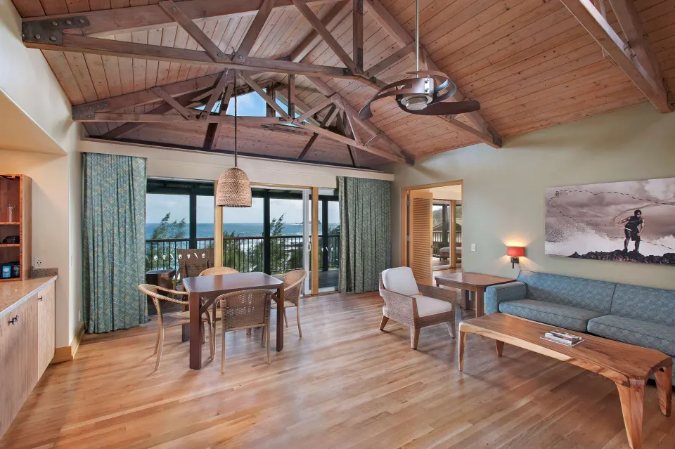 Premier Suite Oceanfront living room with sofa, dining table, and ocean views at Hana-Maui Resort.