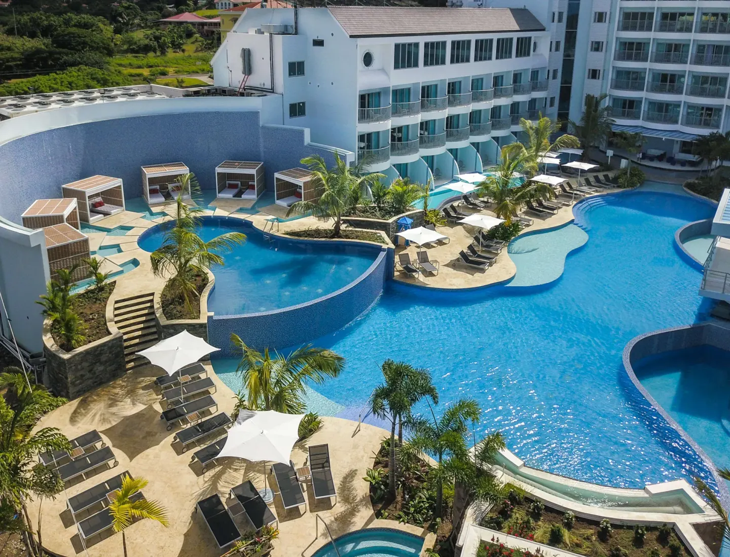 Aerial view of pools, cabanas, and sun loungers at Harbor Club St. Lucia.