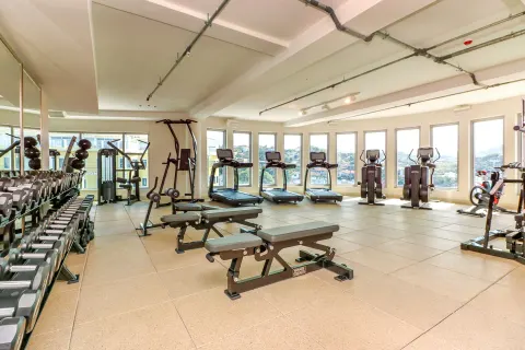 Fitness center with treadmills, benches, and dumbbell racks at Harbor Club St. Lucia.