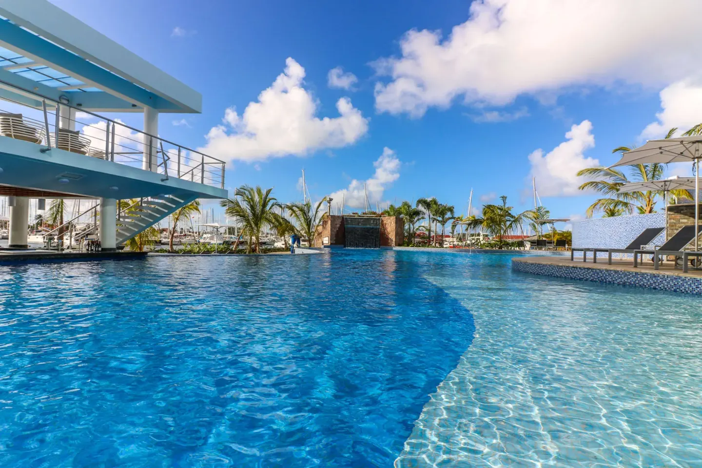 Resort pool with palms and marina backdrop at Harbor Club St. Lucia.