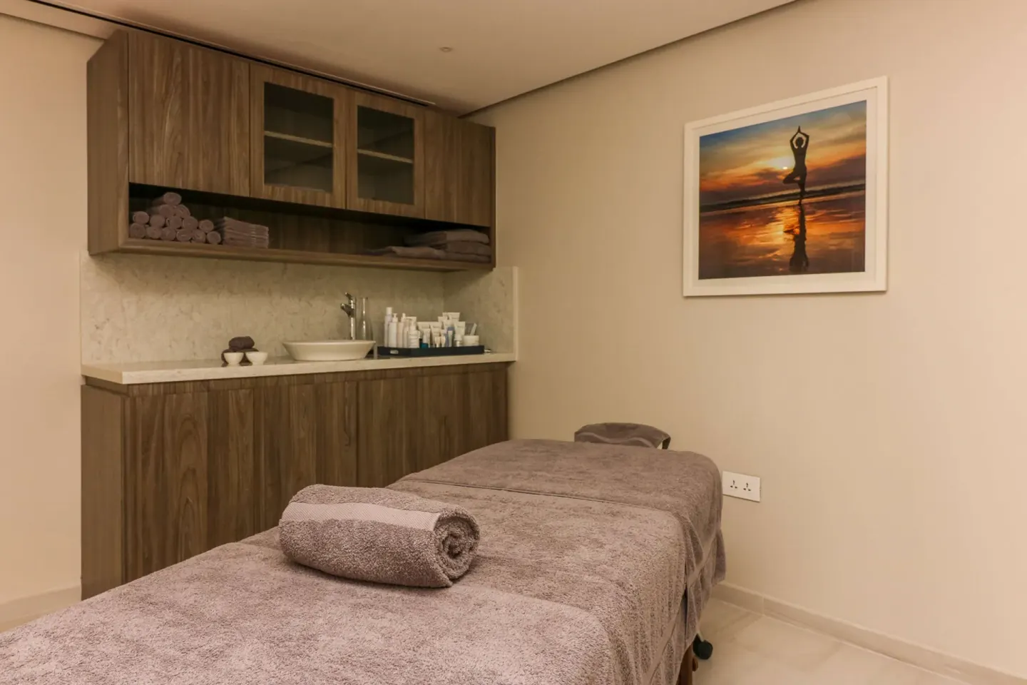 Spa treatment room with massage table and vanity at Harbor Club St. Lucia.