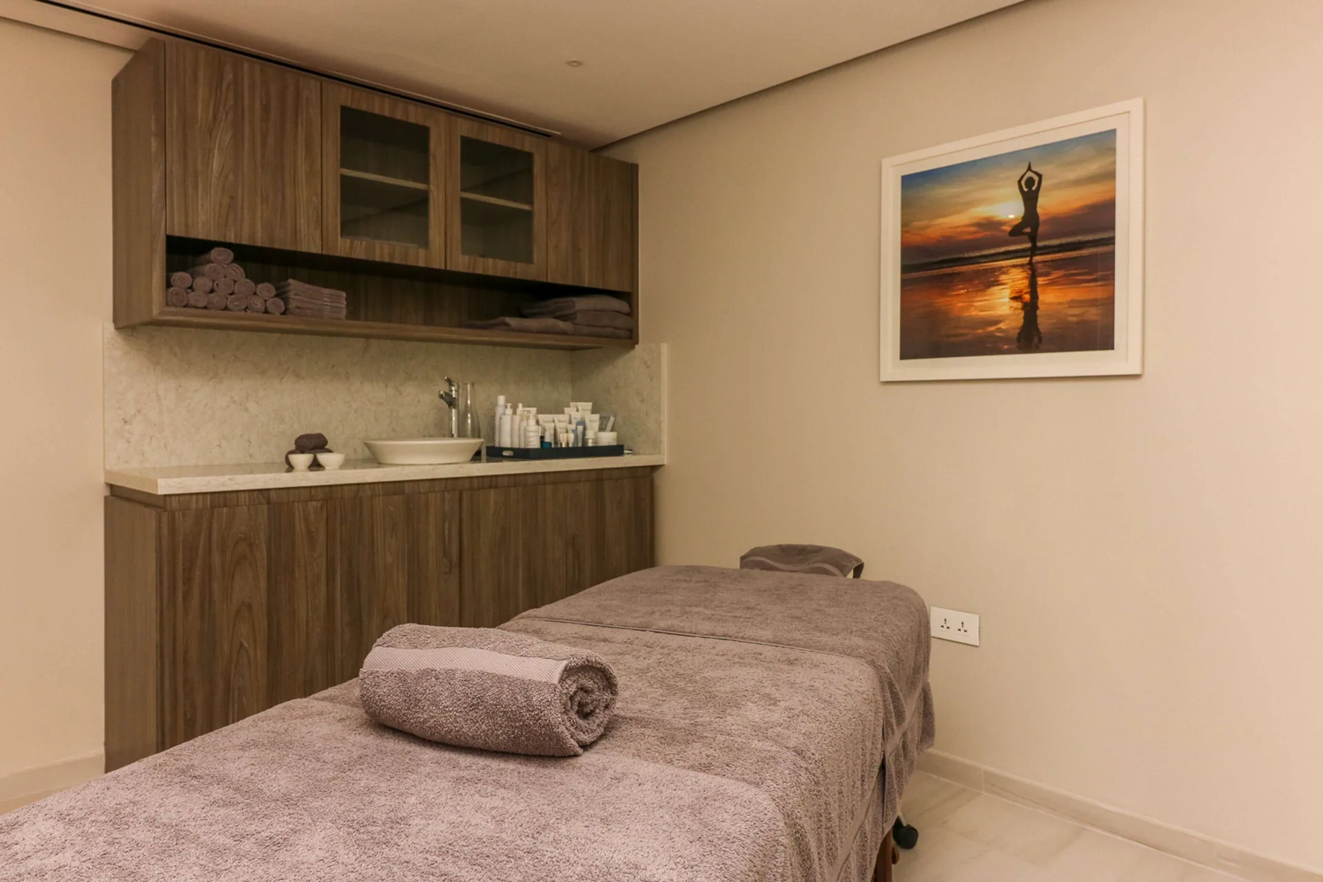 Spa treatment room with massage table and vanity at Harbor Club St. Lucia.