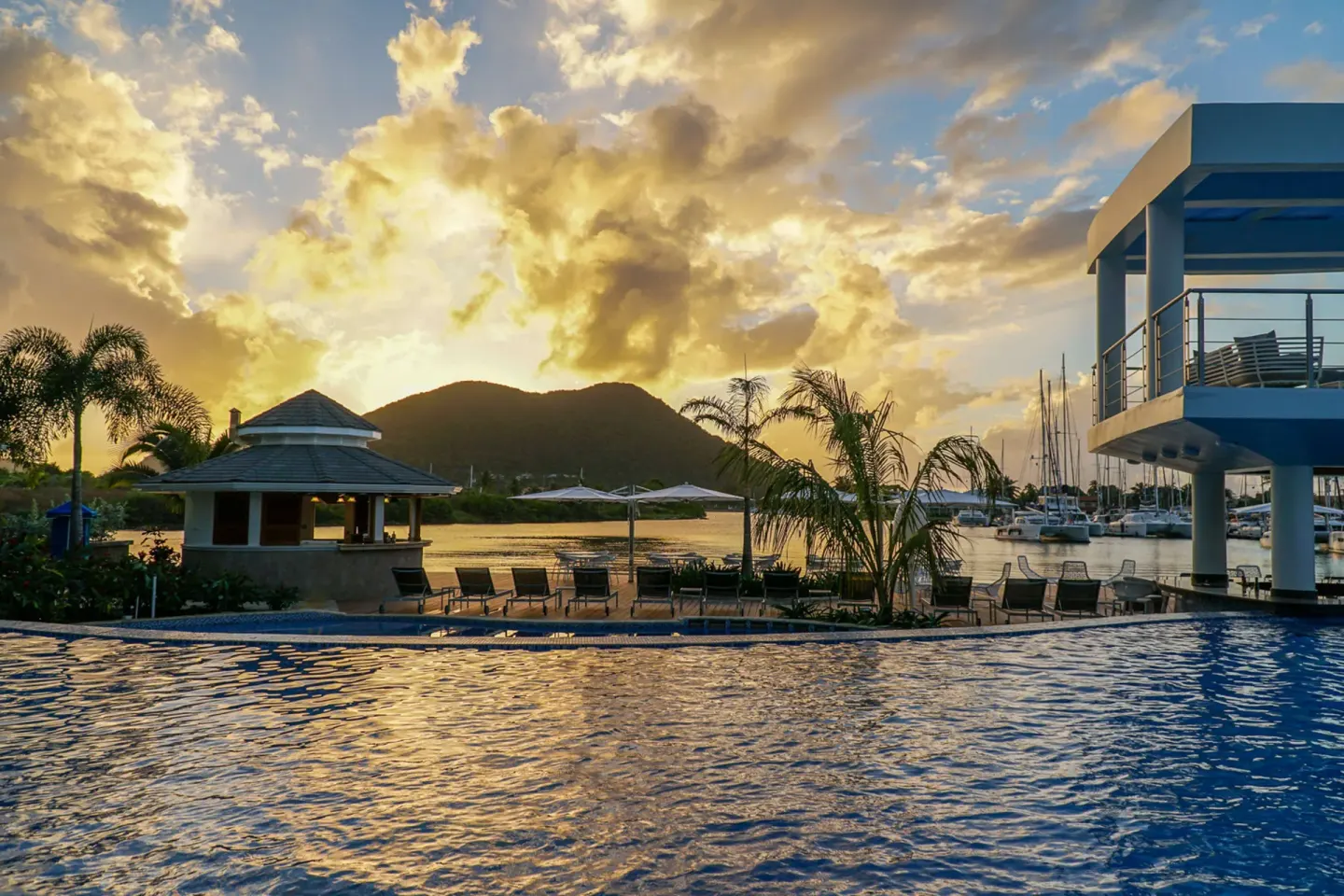 Sunset over the pool, marina, and hills at Harbor Club St. Lucia.