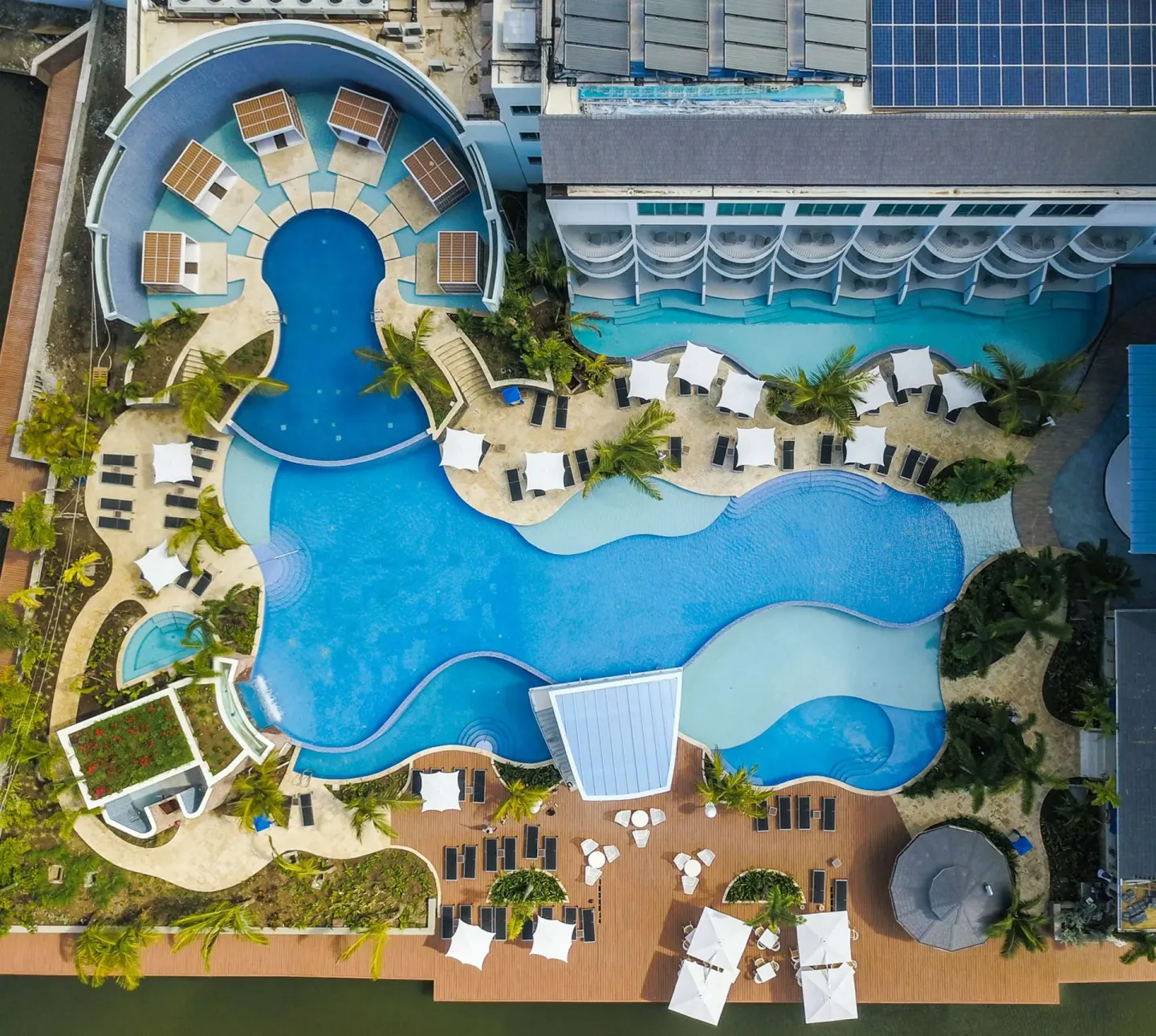 Top-down aerial view of pools, decks, and guest-room balconies at Harbor Club St. Lucia.