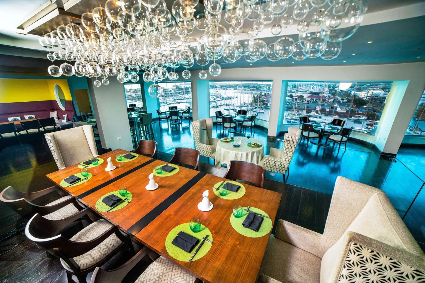 Marina-view dining room with bubble chandelier at Harbor Club St. Lucia.