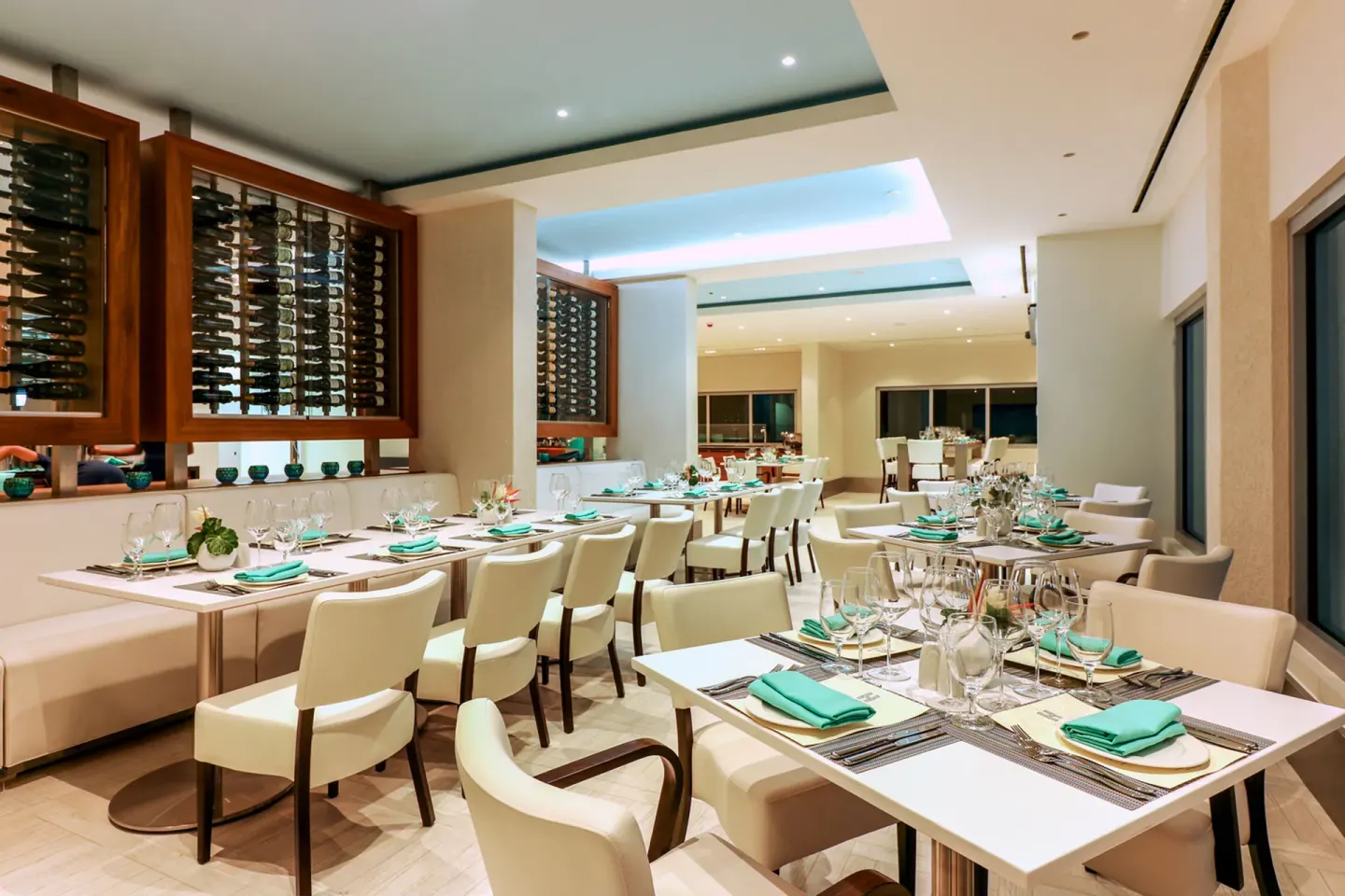 Restaurant dining room with set tables and wine displays at Harbor Club St. Lucia.