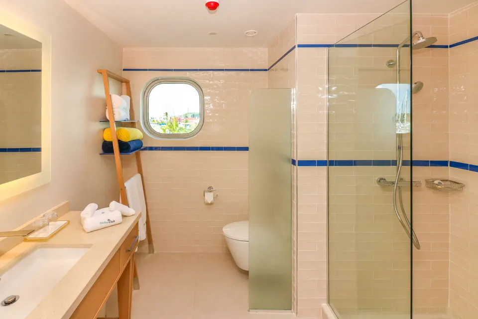 Island View room bathroom with glass shower and blue tile accents at Harbor Club St. Lucia.