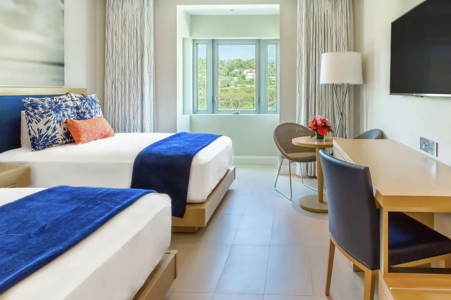 Island View room with two beds, desk, and window at Harbor Club St. Lucia.