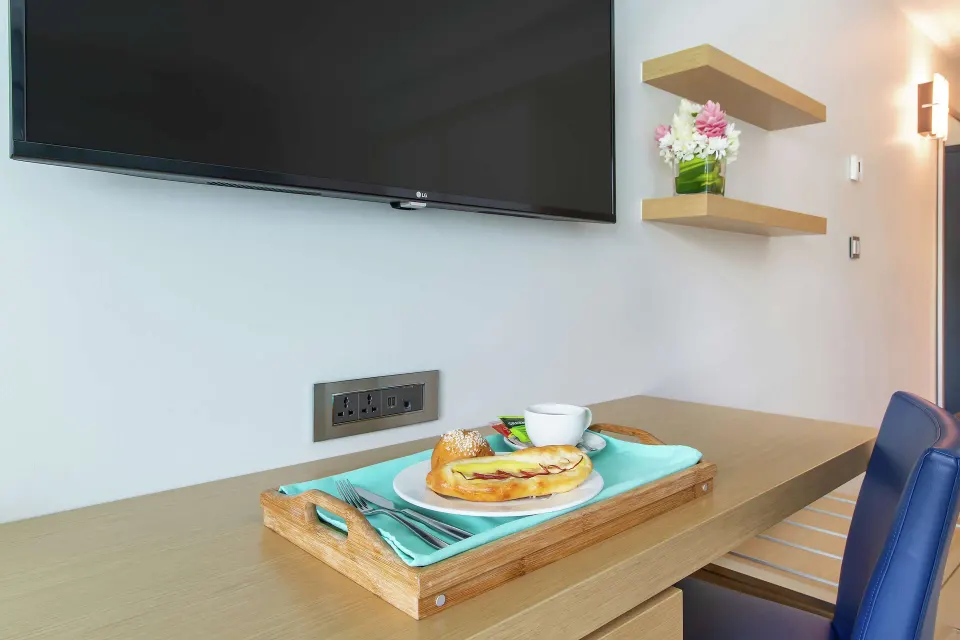 Guest room desk with wall TV and breakfast tray at Harbor Club St. Lucia.
