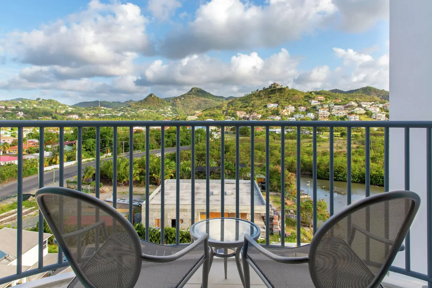 Furnished balcony with chairs and mountain view at Harbor Club St. Lucia.