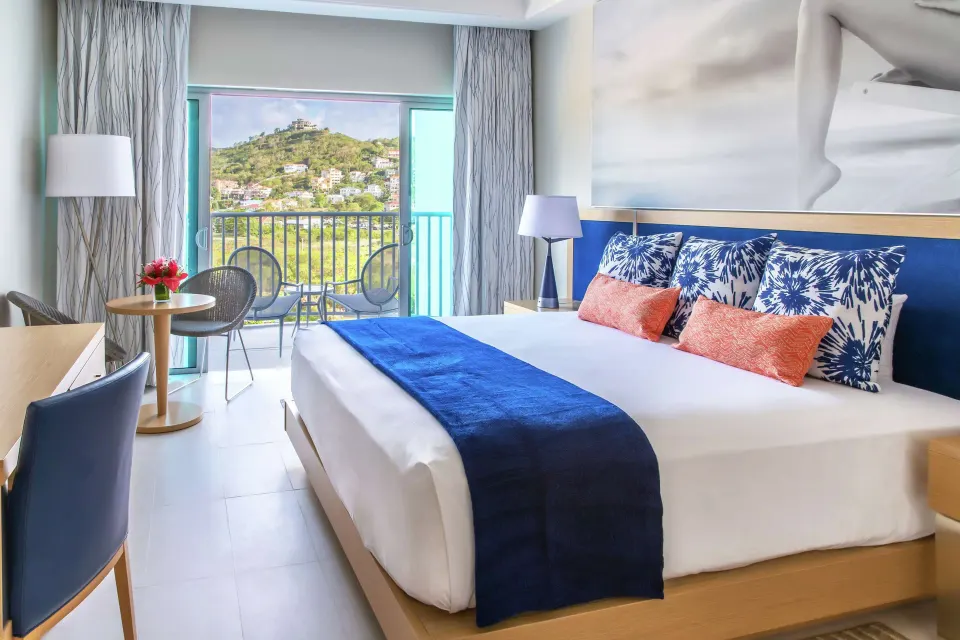 King bed guest room with balcony and mountain view at Harbor Club St. Lucia.