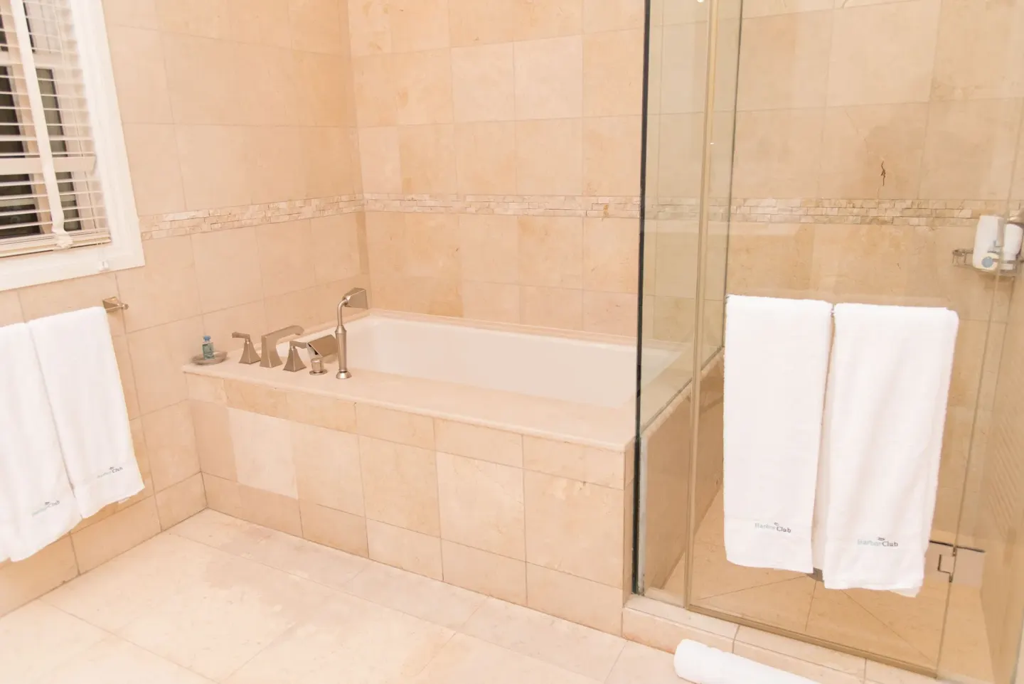 Captain Suite bathroom with tiled soaking tub and glass shower at Harbor Club St. Lucia