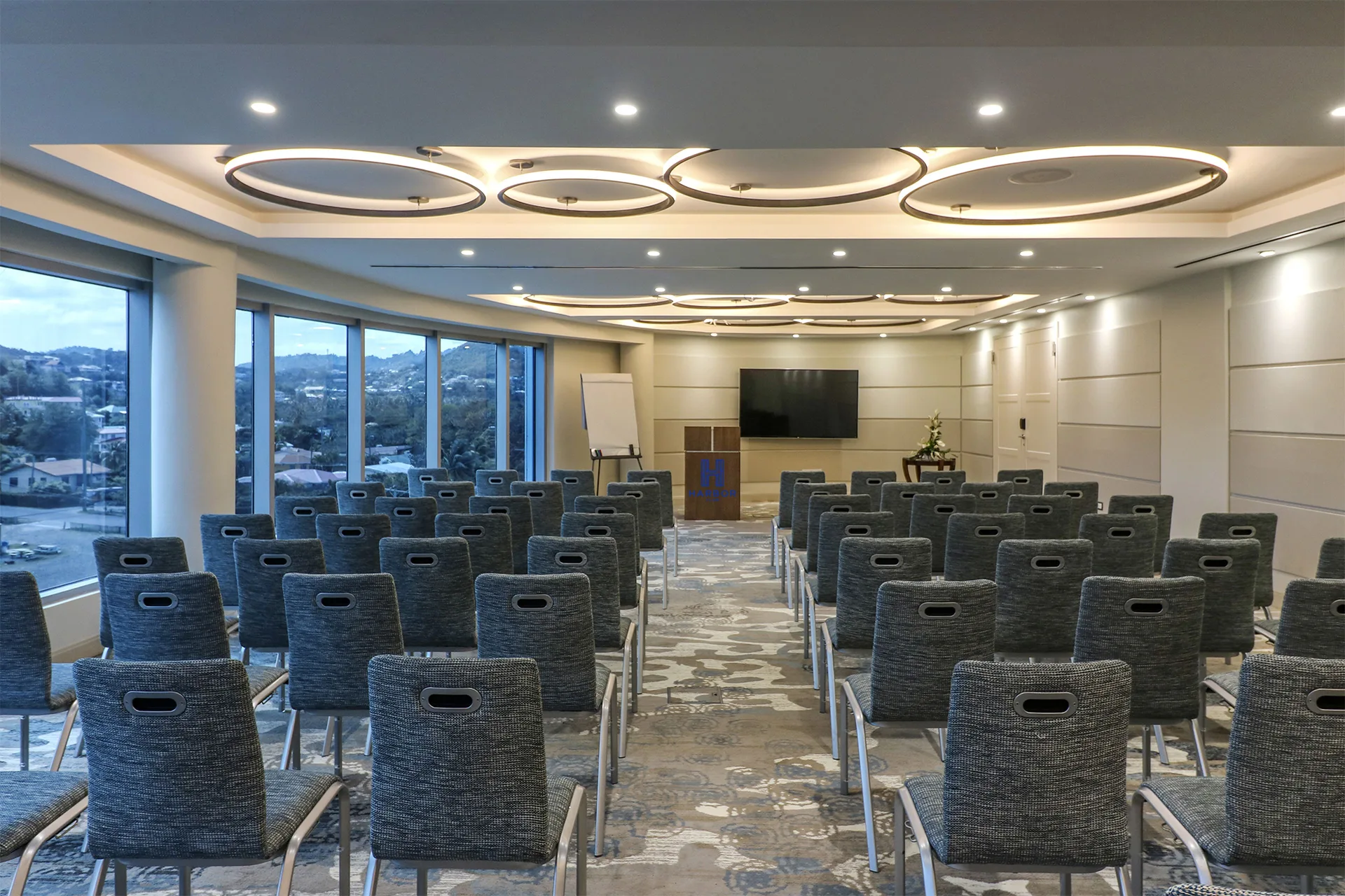 Meeting room with rows of chairs, presentation screen, and city views at Harbor Club St. Lucia.