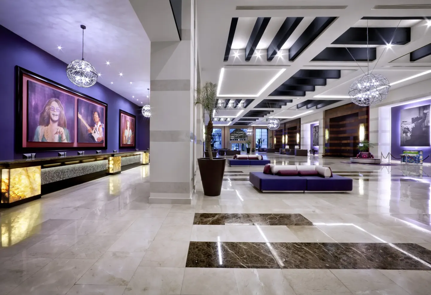 Modern lobby with reception desks and music portraits at Hard Rock Hotel & Casino Punta Cana.