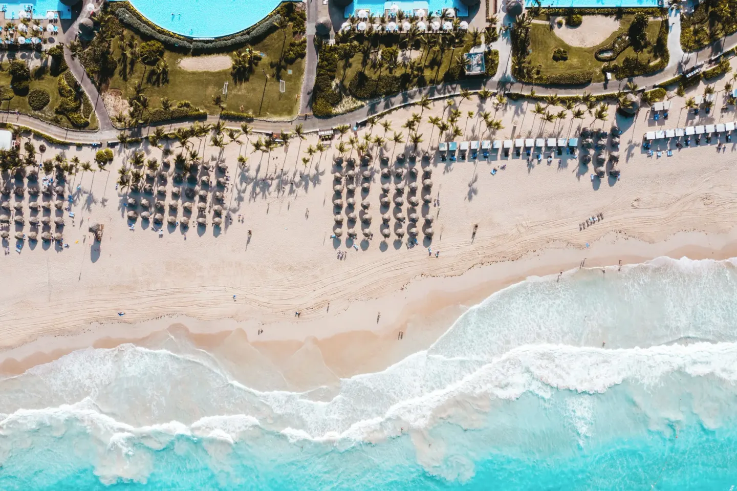 Overhead view of beach palapas and turquoise surf at Hard Rock Hotel & Casino Punta Cana.