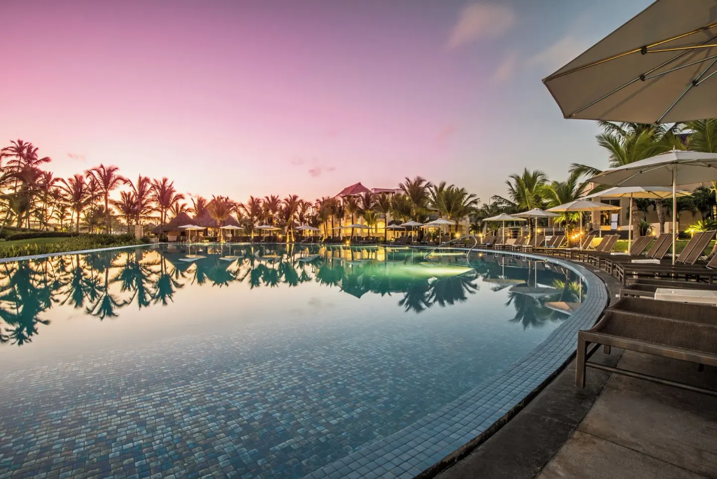 Resort pool at sunset with palms and loungers at Hard Rock Hotel & Casino Punta Cana.