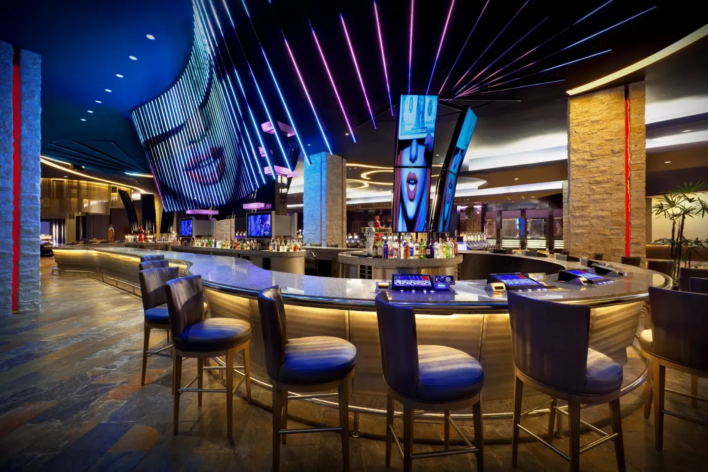 Casino bar at Hard Rock Hotel & Casino Punta Cana with illuminated counters and colorful ceiling lights.