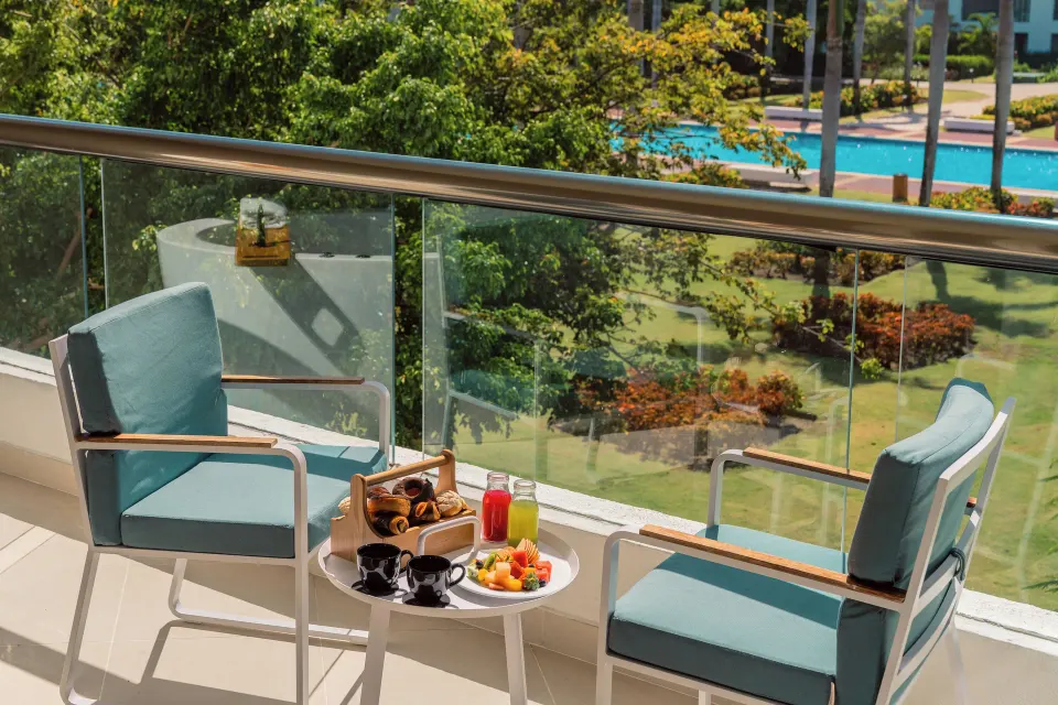 Caribbean Sand Suite balcony breakfast at Hard Rock Hotel & Casino Punta Cana overlooking gardens and pool.