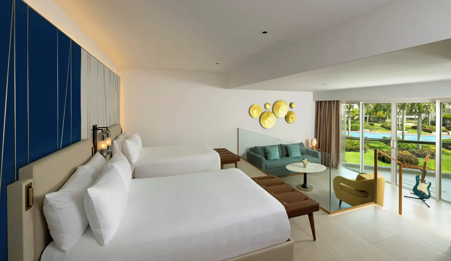 Caribbean Sand Suite double beds at Hard Rock Hotel & Casino Punta Cana with lounge and balcony beyond.