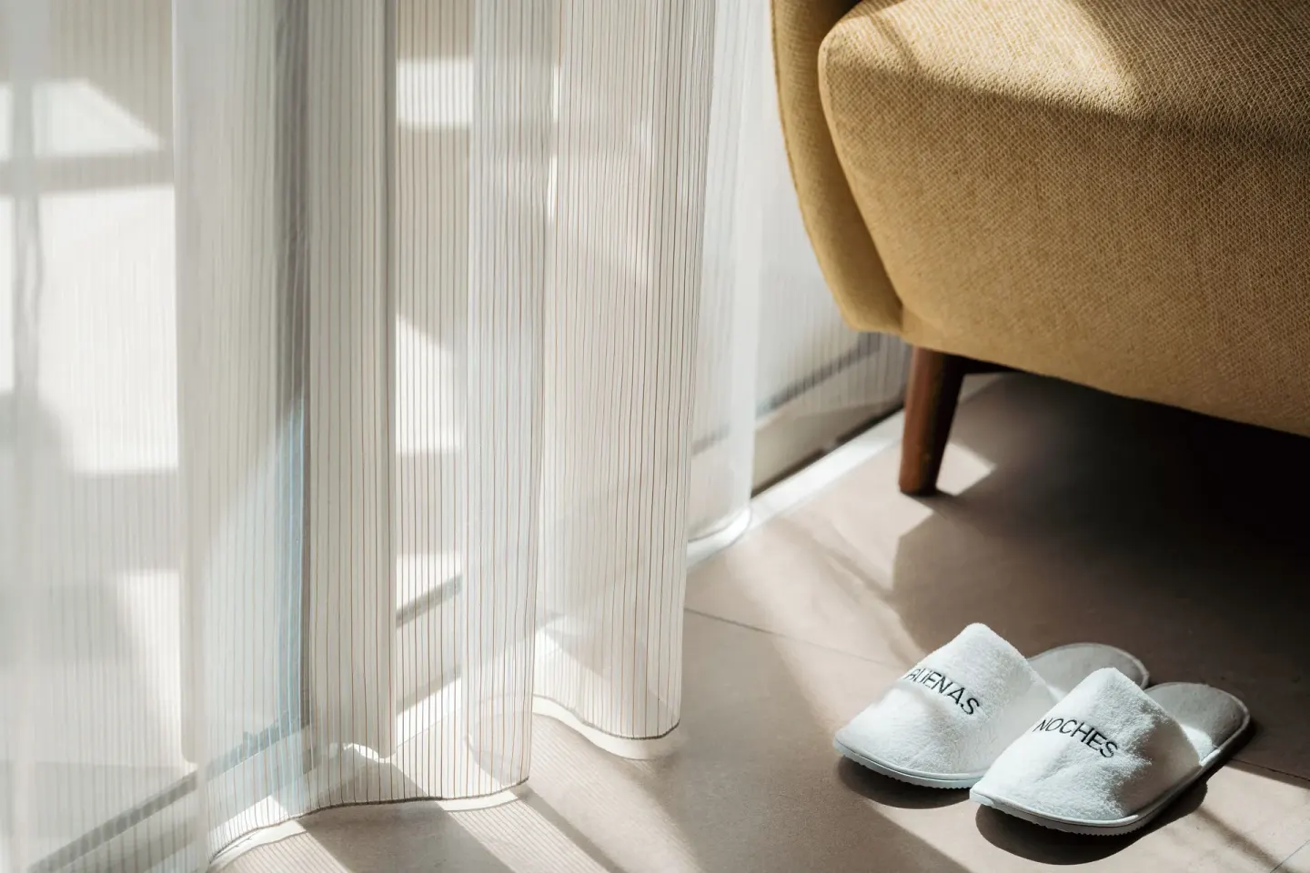 Sunlit suite corner with slippers and chair at Hard Rock Hotel & Casino Punta Cana.