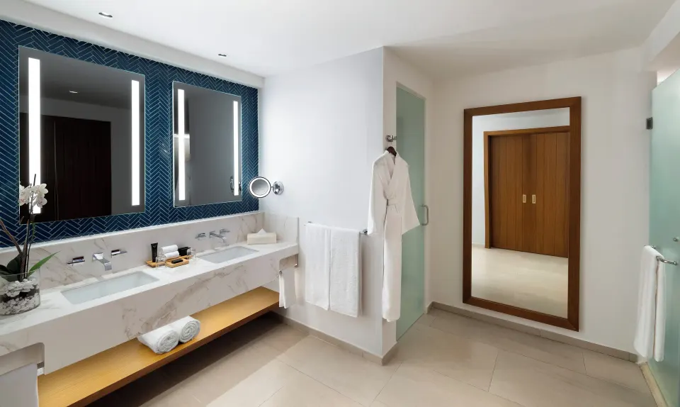 Rock Family Suite bathroom vanity at Hard Rock Hotel & Casino Punta Cana with lit mirrors and robes.