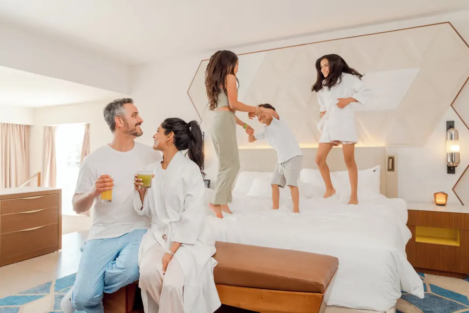 Family gathered on the bed in a Rock Family Suite at Hard Rock Hotel & Casino Punta Cana.