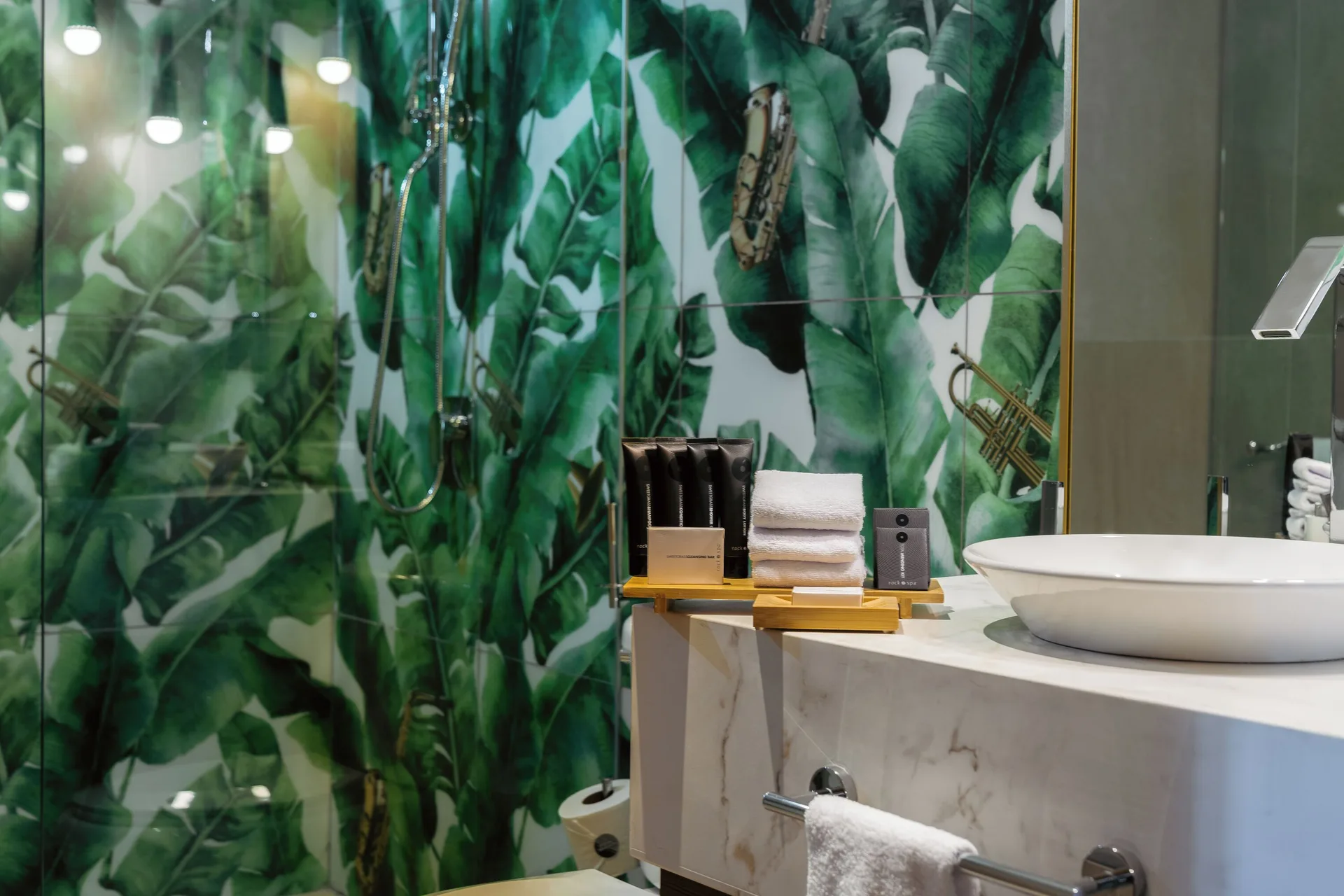 Rock Family Suite bathroom at Hard Rock Hotel & Casino Punta Cana with vessel sink and leaf-pattern shower wall.