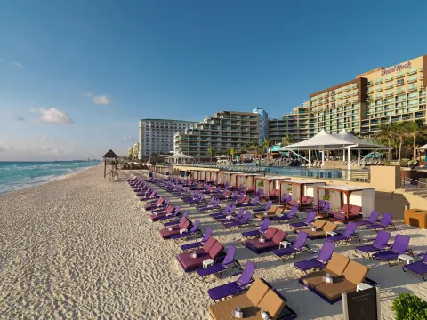 Rows of purple beach loungers and cabanas in front of Hard Rock Hotel Cancun.