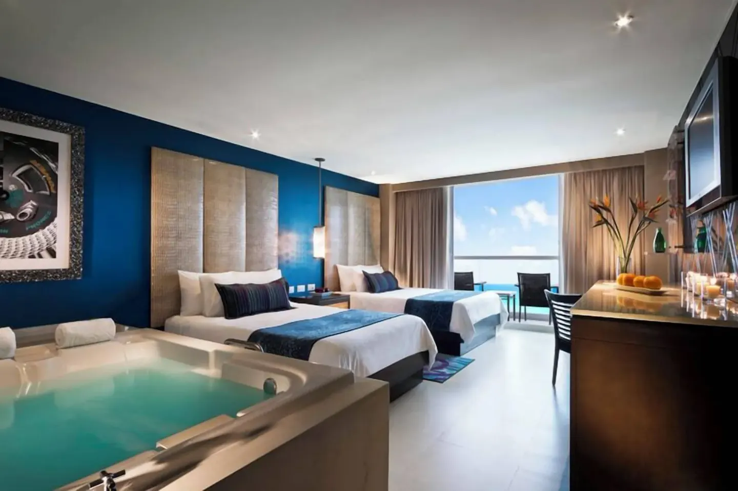 Two-bed guest room with a whirlpool tub and ocean-facing balcony at Hard Rock Hotel Cancun.