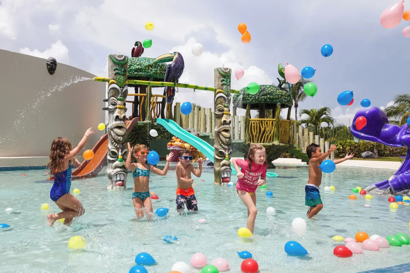Children play in a colorful splash pool at Hard Rock Hotel Cancun.