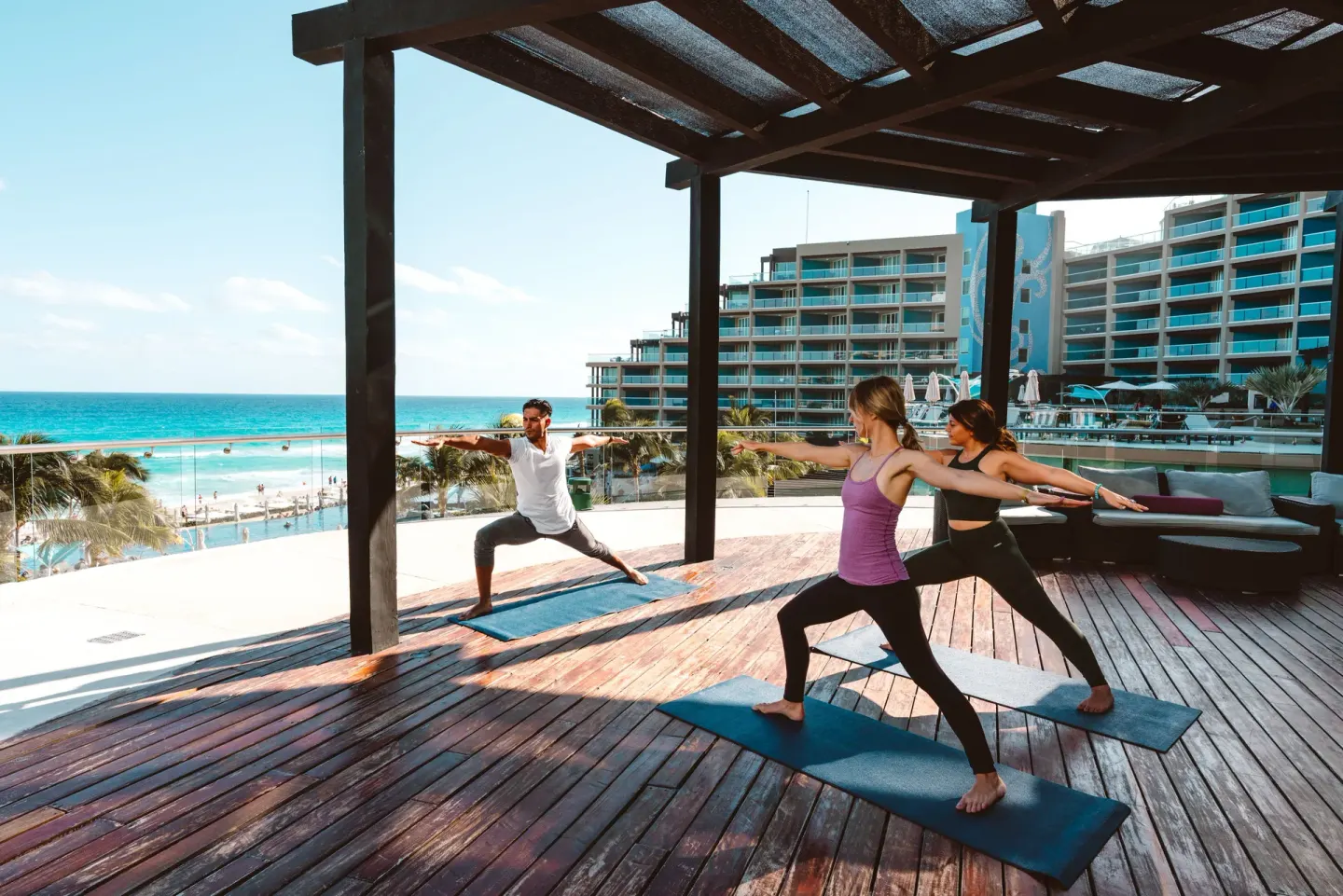 Guests practice yoga on an ocean-view terrace at Hard Rock Hotel Cancun.