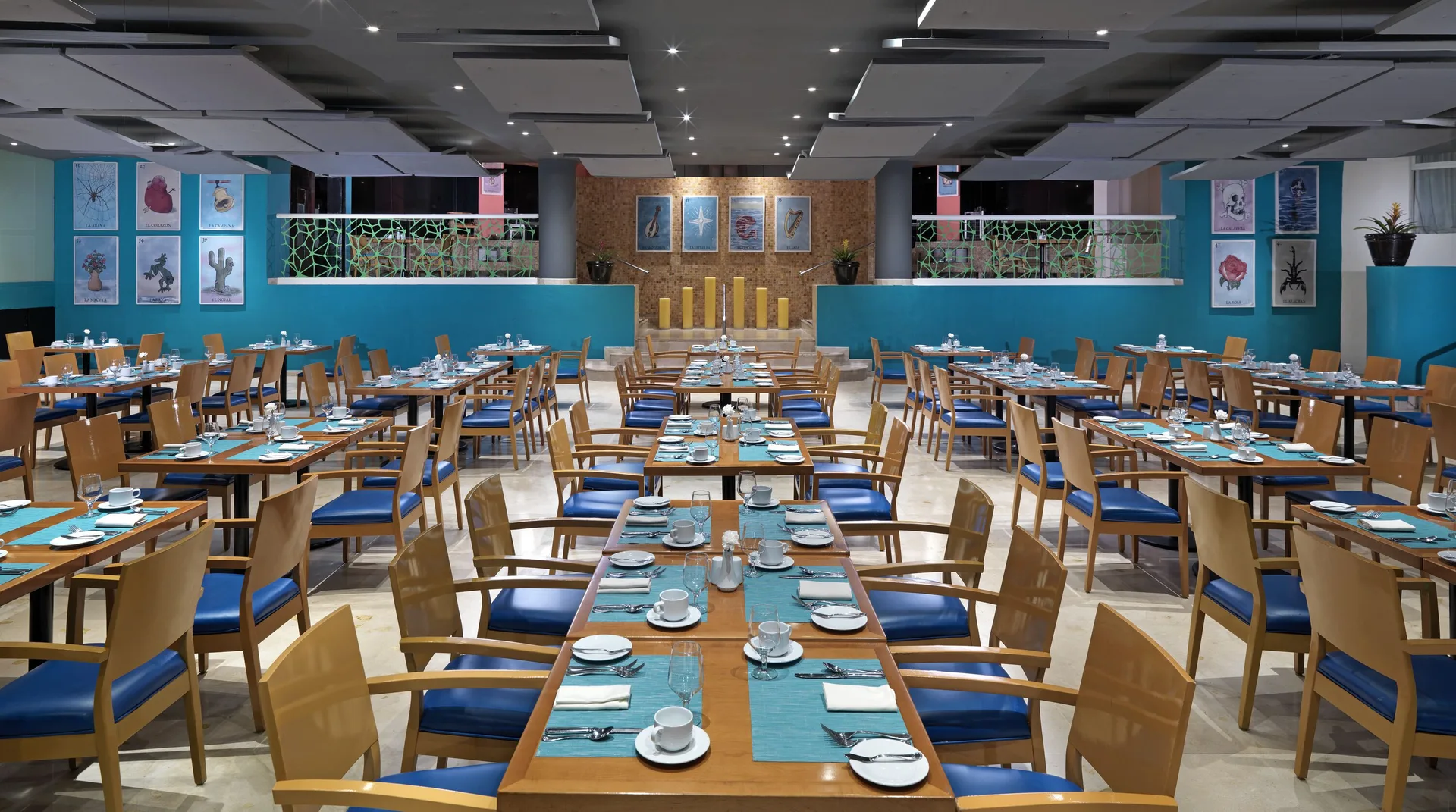 Bright dining room with blue accents and set tables at Hard Rock Hotel Cancun.